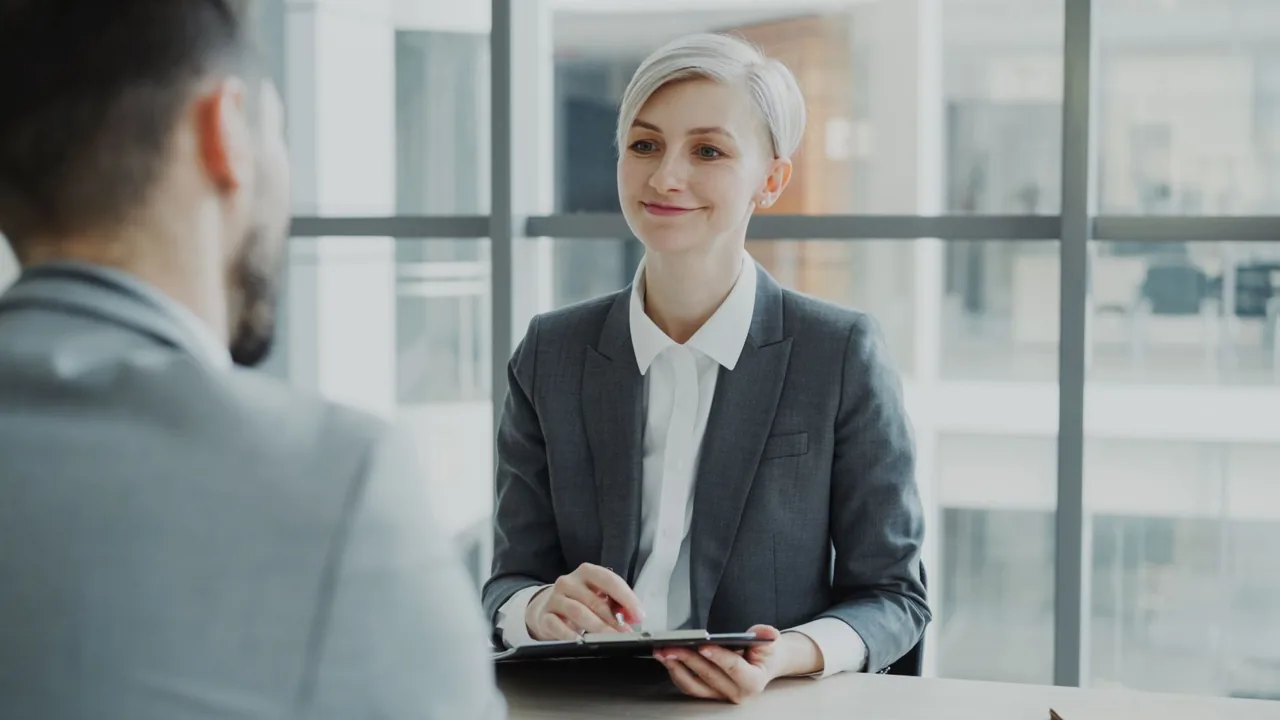 Professionelle Frau im Businessanzug führt ein Vorstellungsgespräch mit einem Bewerber in einem modernen Büro – Symbol für den deutschen Arbeitsmarkt und gefragte Jobs