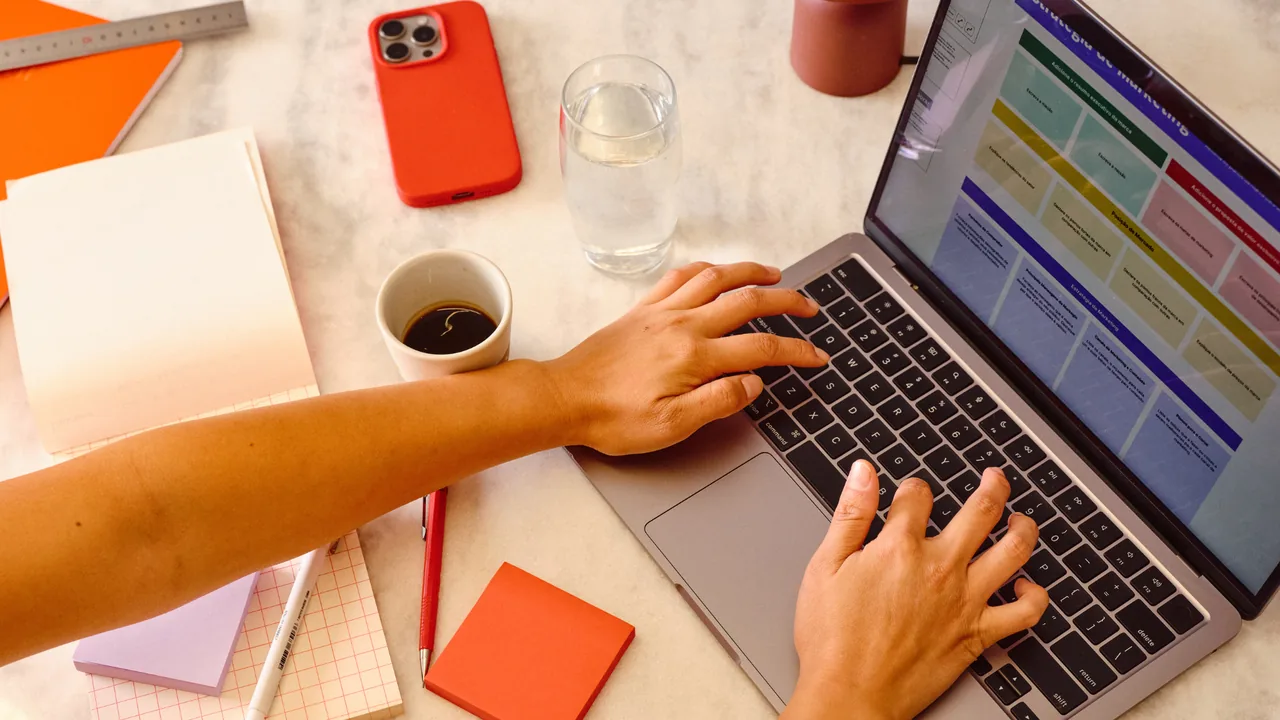Mann schreibt Lebenslauf am Laptop mit beruflichen Unterlagen